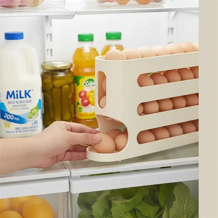 Una mano saca un huevo de la salida inferior dentro de la heladera