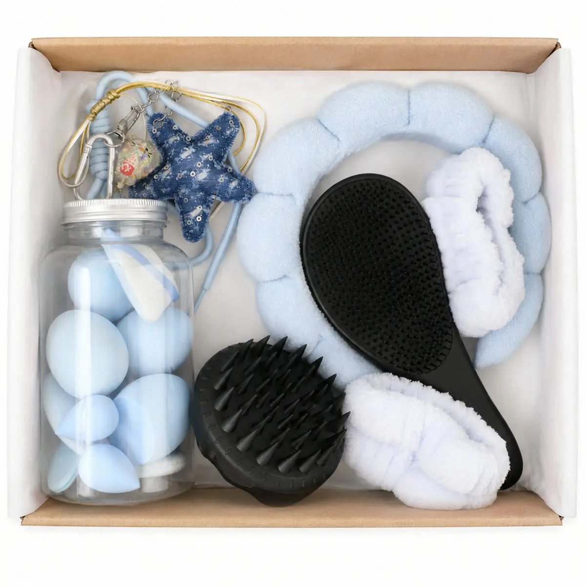 Caja abierta del combo con las esponjas celestes, los dos cepillos negros, la vincha nube, las muñequeras y el charm